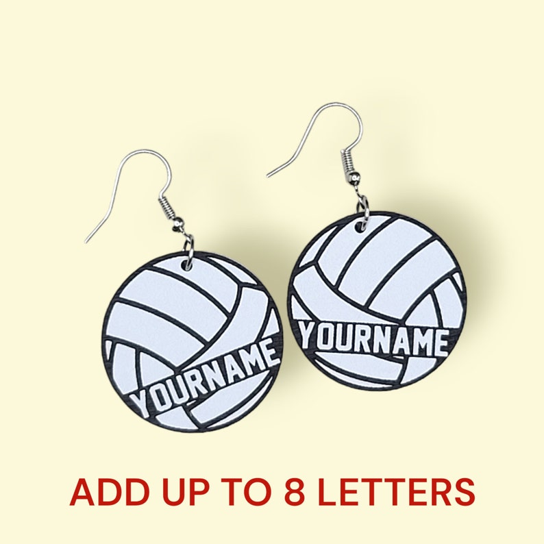 May include: A pair of silver volleyball earrings with a white volleyball design and the text "YOURNAME" in black. Add up to 8 letters.