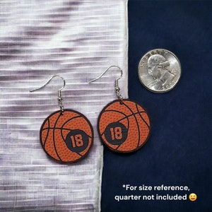Personalized basketball earrings with a players jersey number. Made from lightweight acrylic, they measure 1/8" thick and 1.15" round. Great gift idea for basketball moms!