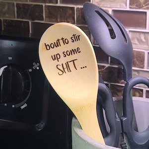 May include: A wooden spoon with the text "bout to stir up some SHIT..." engraved on it.