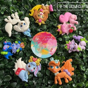 Puede incluir: Un conjunto de nueve figuritas de animales de arcilla de colores, cada una con un diseño y una personalidad únicos. Las figuritas llevan todas coronas y tienen una apariencia caprichosa y de cuento de hadas. Las figuritas son perfectas para añadir un toque de magia a cualquier habitación.