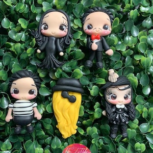 Puede incluir: Cinco figuritas de arcilla pintadas a mano de personajes de la familia Addams. Los personajes incluyen a Gomez, Morticia, Wednesday, Pugsley y el tío Fester. Las figuritas llevan todas sus atuendos característicos y tienen rasgos faciales detallados. @THE LITTLE CLAY SHOP