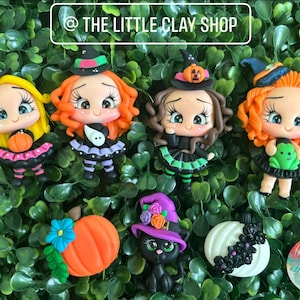 May include: Five Halloween-themed clay figurines.  The figurines are of witches wearing black and green dresses with hats.  One witch is holding a pumpkin, another is holding a frog, and another is holding a ghost.  There is also a black cat figurine wearing a purple hat and a white pumpkin figurine.