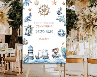 Könnte beinhalten: Ein weißes Willkommens-Schild mit nautischem Thema für eine Babyparty. Das Schild zeigt einen Leuchtturm, ein Segelboot, einen Teddybär mit Matrosenmütze, einen Kompass, einen Rettungsring und eine Flasche mit einer nautischen Flagge. Der Text auf dem Schild lautet "Vielen Dank, dass Sie zur Babyparty von Jennifer gekommen sind 05.22.20XX".
