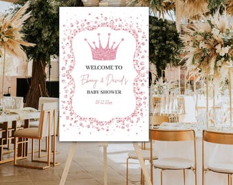 Puede incluir: Un cartel de bienvenida blanco con una corona rosa de purpurina y el texto "Bienvenido a Ebony & David's Baby Shower 05.22.20xx".
