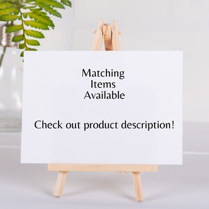 K&ouml;nnte beinhalten: Ein kleiner Holzstaffelei mit einer wei&szlig;en Karte, auf der "Matching Items Available Check out product description!" steht.