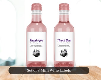 May include: Set of eight mini wine bottle labels with a black and white illustration of a cauldron with a crescent moon and stars. The labels have the text "Thank You for celebrating with us! Pop this when baby Jason makes his debut!"