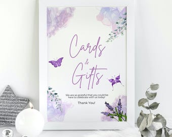 May include: A white framed sign with the words "Cards & Gifts" in purple script, decorated with watercolor lavender and butterflies. The sign includes the text "We are so grateful that you could be here to celebrate with us today! Thank You!"