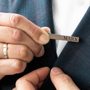 a close up of a person wearing a suit and tie