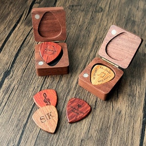 a couple of wooden guitar picks sitting on top of a wooden table