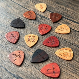 a group of wooden guitar picks with names on them