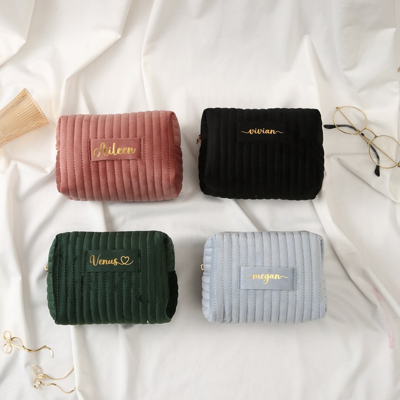 a group of three purses sitting on top of a bed
