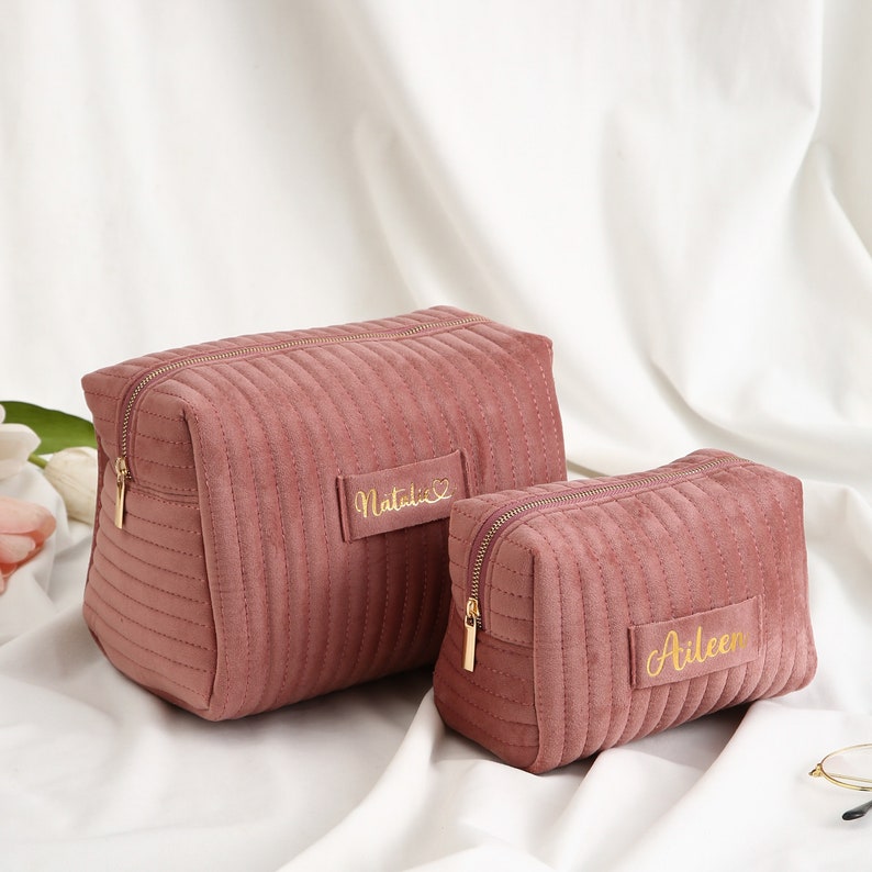 a couple of pink bags sitting on top of a bed