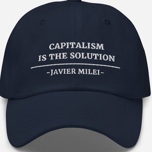May include: Navy blue baseball cap with white embroidered text: "CAPITALISM IS THE SOLUTION" and "-JAVIER MILEI-". The cap has a curved brim and a six-panel design. A classic, adjustable hat.
