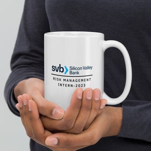 May include: White ceramic mug with a blue and black logo that reads "svb> Silicon Valley Bank" and "RISK MANAGEMENT INTERN - 2023"