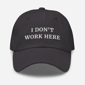 etailed view of the bold and witty "I Don't Work Here" print on our high-quality cap. Perfect for those who enjoy clever and cheeky fashion that sparks conversations.