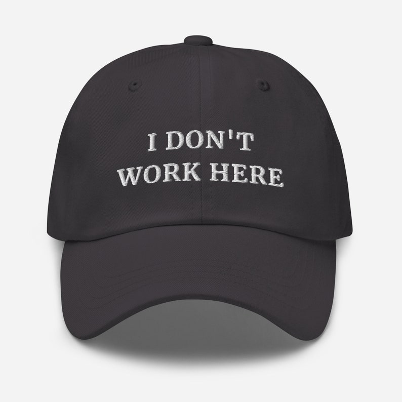 etailed view of the bold and witty "I Don't Work Here" print on our high-quality cap. Perfect for those who enjoy clever and cheeky fashion that sparks conversations.