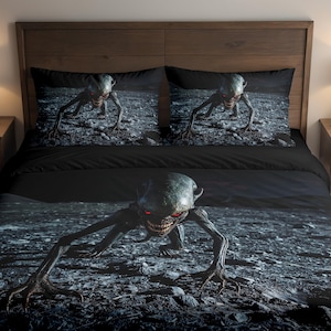 May include: Black bedding set featuring a menacing creature with red eyes and sharp teeth, crawling on a rocky surface. The set includes a duvet cover and two pillowcases, all with the same graphic design. The overall theme is horror.