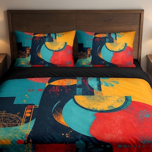 Op de afbeelding: Een beddengoedset met een abstract ontwerp in teal, geel, rood en marineblauw. De set bevat een dekbedovertrek en twee kussenslopen. Het bed staat op een houten frame, met twee nachtkastjes en lampen.