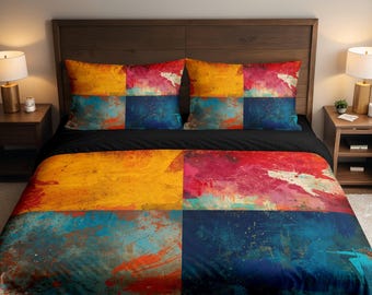 May include: A bed set featuring a duvet cover and two pillowcases. The bedding has a colorful abstract design with yellow, red, blue, and white paint strokes. The bed is made with a black sheet and a dark wooden headboard.