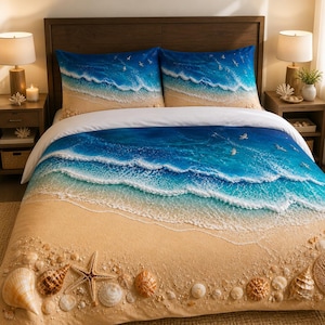 Op de afbeelding: Een beddengoedset met een print van een zandstrand met verspreide schelpen en een zeester aan de onderkant, overgaand in turquoise oceaangolven met wit zeeschuim en kleine vogels die over het diepblauwe water vliegen.
