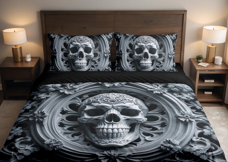May include: A black and white skull-themed bedding set. The duvet cover and two pillowcases feature a detailed skull design within an ornate frame. The skull has intricate details, and the overall aesthetic is gothic.