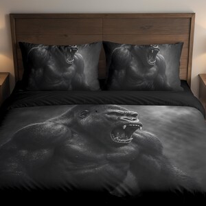 Pode incluir: Conjunto de roupa de cama a preto e branco com uma ilustração detalhada de um gorila com a boca aberta. O conjunto inclui uma capa de edredão e duas fronhas, todas com o mesmo design. A cama é feita com um lençol preto.