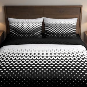 Peut inclure: Une parure de lit à pois noirs et blancs. L'ensemble comprend deux taies d'oreiller, un drap-housse et une housse de couette. Les pois passent du blanc au noir. Le lit est composé d'une tête de lit en bois foncé.