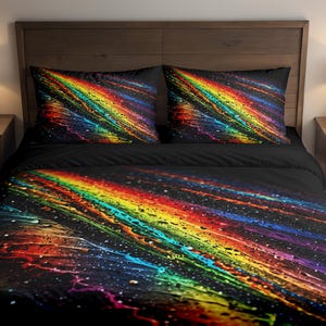 Op de afbeelding: Een zwart beddengoed met een levendig, abstract ontwerp. Het patroon bevat strepen in regenboogkleuren, waaronder rood, oranje, geel, groen, blauw en paars, tegen een donkere achtergrond. De set bevat een dekbedovertrek en twee kussenslopen.