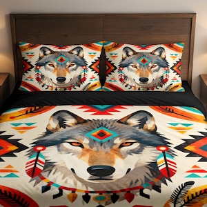 Könnte beinhalten: Bettwäsche-Set mit Wolfsmotiv und indianisch inspirierten Mustern. Das Set beinhaltet einen Bettbezug und zwei Kissenbezüge, die ein detailliertes Wolfsporträt mit farbenfrohen geometrischen Akzenten zeigen. Die Farbpalette umfasst Creme, Schwarz, Orange und Türkis.