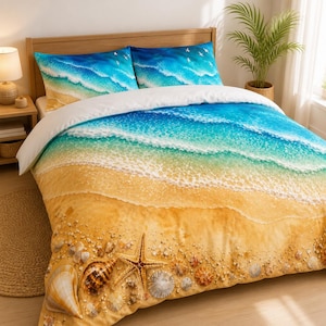 May include: A bedding set featuring a printed design of a sandy beach with scattered seashells and a starfish at the bottom, transitioning into turquoise ocean waves and white sea foam, with two matching pillowcases showing a similar coastal scene.