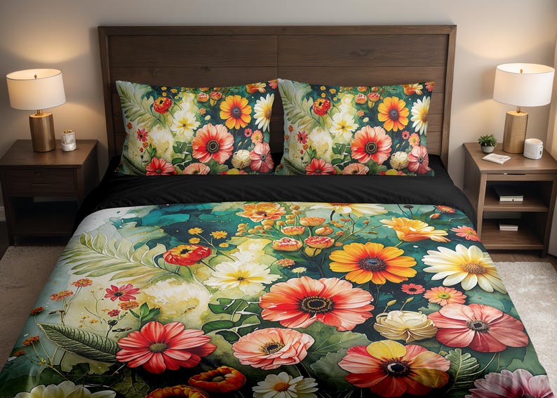 May include: Floral bedding set featuring a vibrant watercolor design. The set includes a duvet cover and two pillowcases adorned with large, colorful flowers in shades of red, orange, yellow, and white against a dark background. The bed is made up with a black sheet.
