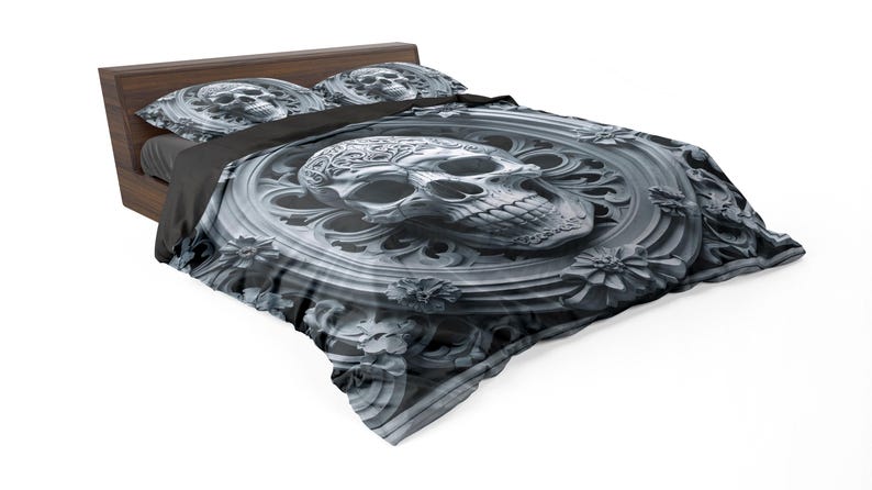 May include: A bed with a dark wooden frame and a skull-themed bedding set. The comforter and pillowcases feature a detailed, grayscale skull design with floral accents, creating a gothic aesthetic. The bedspread is a dark gray color.