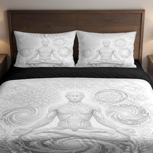 Puede incluir: Un juego de cama en blanco y negro con una ilustración detallada de una figura meditando. El juego incluye una funda nórdica y dos fundas de almohada, todas con un diseño similar. La obra de arte está en una paleta de colores en escala de grises.