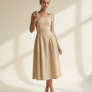rehearsal dinner dress bow Bow Details. For her rehearsal dinner, Emily chose a chic midi-length faille dress featuring a straight-across neckline, an angular ruffle at the hem, and a statement bow at the bust. Dress: Stand