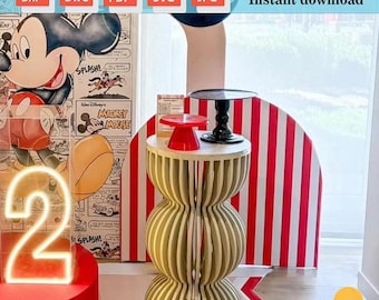 May include: A digital download of a Mickey Mouse themed party backdrop with red and white stripes, a neon number two, and a white and beige table with a red and white striped base. The backdrop is a half circle shape and the table is a double-tiered design.