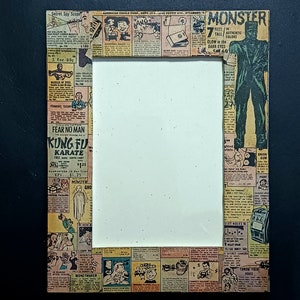 Może przedstawiać: Ramka na zdjęcia w stylu vintage wykonana z komiksowej strony. Ramka jest otoczona kolorowymi panelami komiksowymi z reklamami produktów, takich jak sekretny teleskop szpiegowski, pieniący się cukier i figurka potwora. Ramka jest pusta i gotowa na zdjęcie.