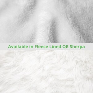 May include: Close-up of two white, textured fabrics. The top fabric is a smooth fleece, and the bottom fabric is a fluffy sherpa. The text "Available in Fleece Lined OR Sherpa" is displayed in a green banner across the middle of the image.