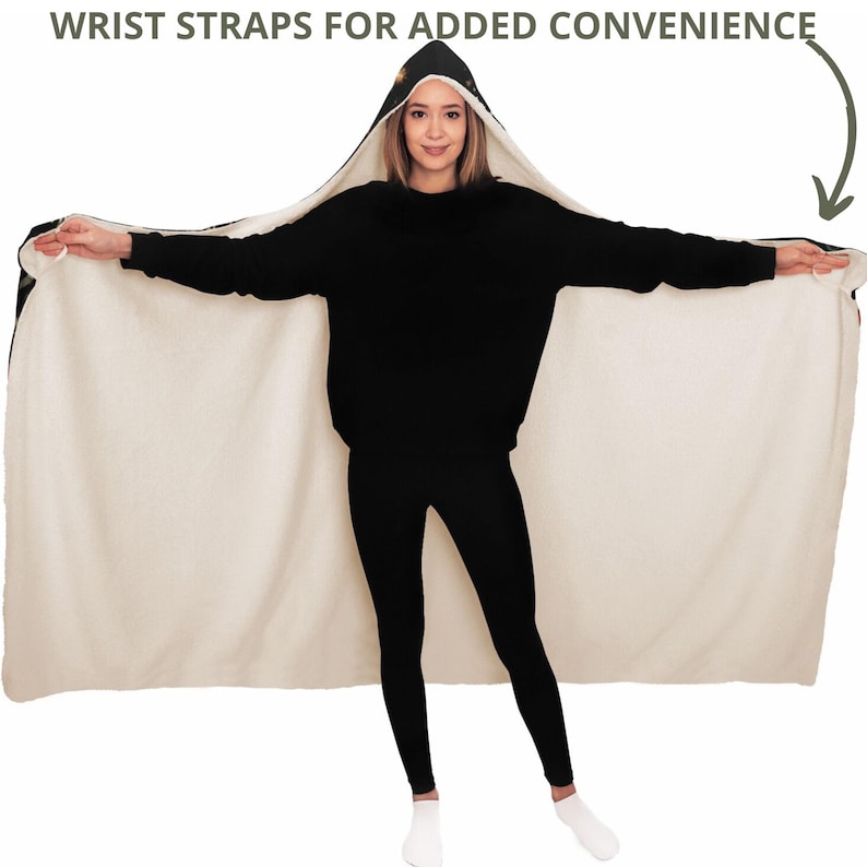 Puede incluir: Una manta negra con capucha y forro de borreguillo blanco. La manta tiene correas para las mu&ntilde;ecas para mayor comodidad. La modelo lleva la manta como una bata.
