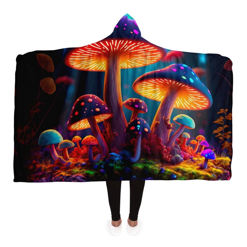 May include: Hooded blanket featuring a vibrant illustration of glowing mushrooms in a dark forest setting. The design showcases a variety of colorful fungi with orange, blue, and purple hues. The blanket has a hood and is designed to be worn.