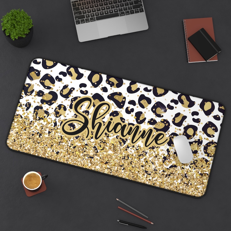 May include: A rectangular mousepad with a white background, black and gold leopard print, and gold glitter effect. The name "Shianne" is written in a gold script font. A computer mouse rests on the pad.