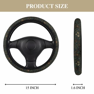 May include: A black steering wheel with a floral pattern cover. The cover features a dark green background with small, light-colored flowers. The steering wheel is 15 inches in diameter and 1.6 inches wide.