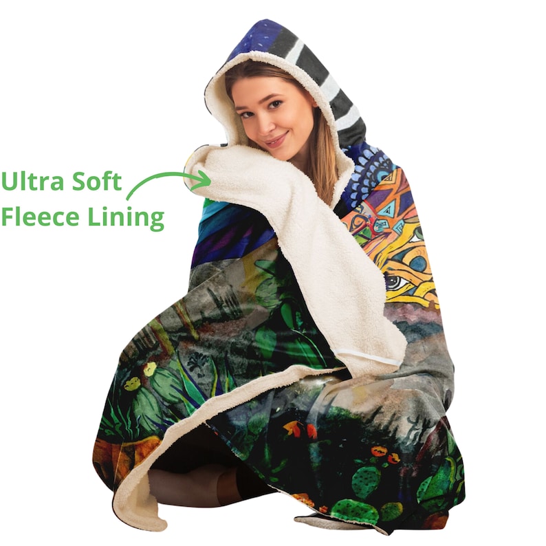 May include: A hooded blanket with an abstract design featuring a variety of colors, including green, blue, and yellow. The hood has a striped pattern in black and white. The blanket has an ultra-soft fleece lining.