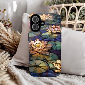May include: A phone case with a stained glass design featuring water lilies in shades of yellow, white, and blue. The case has a black background and a camera lens cutout.