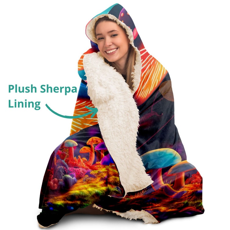 May include: A hooded blanket with a colorful mushroom design. The blanket features a plush sherpa lining for added warmth and comfort. The design includes vibrant orange, red, blue, and purple hues, creating a psychedelic landscape.