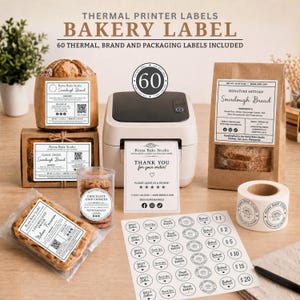 May include: A thermal printer with various bakery labels, including rectangular stickers on a sourdough bread bag, a cookie jar, and a loaf box, plus a sheet of circular stickers and a roll of labels featuring Roma Bake Studio branding.