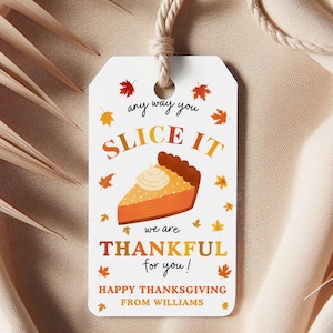 May include: A white gift tag with a Thanksgiving theme. The tag features a slice of pie and fall leaves. Text on the tag reads "any way you slice it, we are thankful for you!" and "Happy Thanksgiving from Williams."