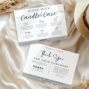 May include: Two white cards with black text. One card reads "Wood Wick Candle Care" with instructions. The other says "Thank You For Your Purchase". Both cards have a gray border and are on a white cloth.