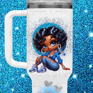 May include: White tumbler with a handle, featuring a cartoon illustration of a woman in blue clothing, surrounded by a blue glitter circle. The word "Angel" is written in blue glitter. Includes a white lid and straw.