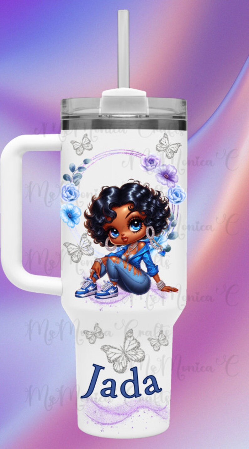 May include: White tumbler with a handle, featuring a cartoon illustration of a girl in blue denim and a jacket. The design includes butterflies, flowers, and the name "Jada" in blue. A white straw is visible.