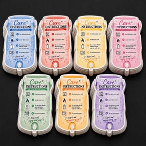 Op de afbeelding: Zeven stapels gestanste kaarten in de vorm van drankkoelers in blauw, roze, geel, lichtroze, groen, oranje en paars. Elke kaart bevat de tekst Care Instructions for your 12oz can coozie, vier genummerde iconen en de zin Keep it cool, enjoy every sip!